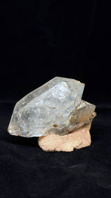 透明晶體的另一側寬面向左下延伸，右後方露出較小晶體，下緣帶褐色細節。