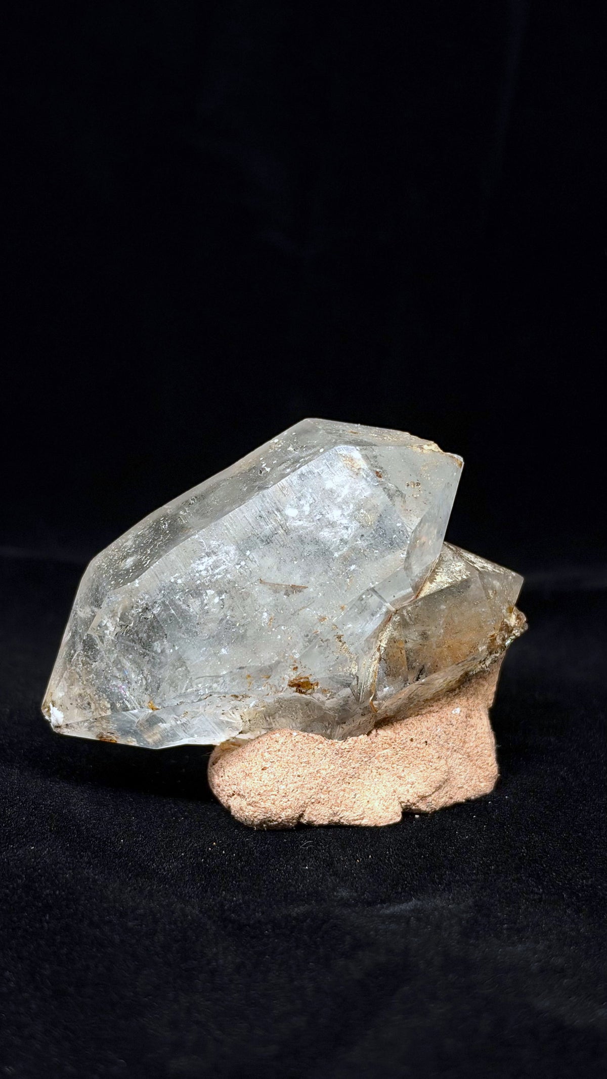 透明晶體的另一側寬面向左下延伸，右後方露出較小晶體，下緣帶褐色細節。